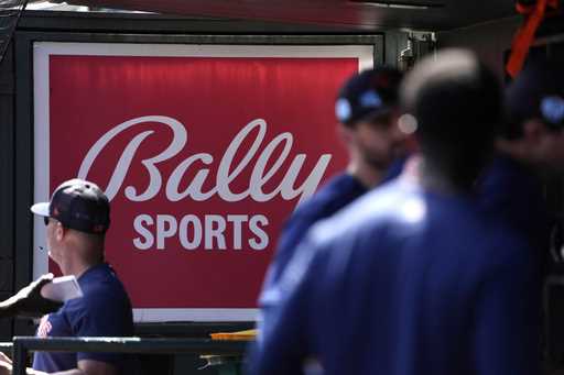 FILE -A Bally Sports sign hangs in a dugout before the start of a spring training baseball game bet…