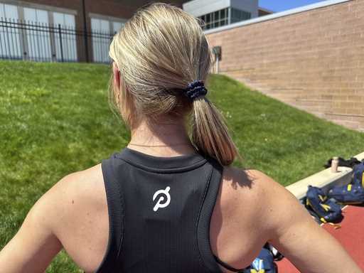 Michigan junior Riley Ammenhauser shows a Peloton logo on her shirt, Tuesday, April 30, 2024 in Ann…