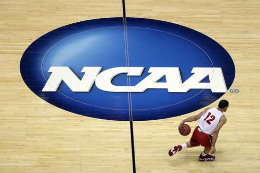 Wisconsin's Traevon Jackson dribbles past the NCAA logo during practice at the NCAA men's college b…