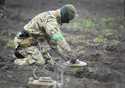 An interior ministry sapper defuses a mine on a minefield after recent battles in Irpin close to Ky…