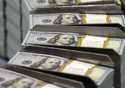Cut stacks of $100 bills make their way down the line at the Bureau of Engraving and Printing Weste…