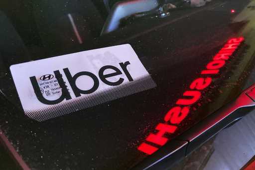 An Uber sign is displayed inside a car in Glenview, Ill
