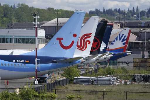 Boeing 737 Max airplanes, including one belonging to TUI Group, left, sit parked at a storage lot, …