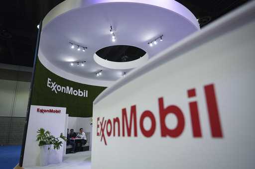 Delegates meet at the Exxon Mobil booth during the LNG2023 conference in Vancouver, British Columbi…