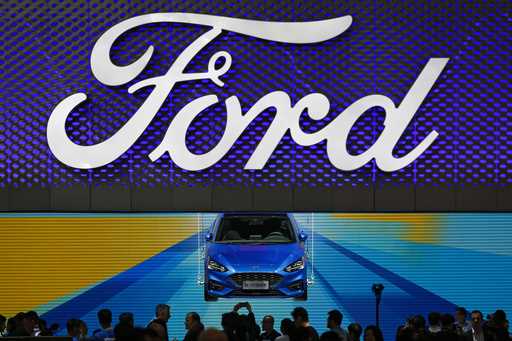 FILE- In this April 25, 2018, photo, visitors and journalists gather near a Ford Focus on display a…