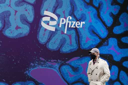 A man walks by Pfizer headquarters, Friday, February 5, 2021, in New York