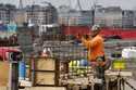 A construction worker prepares a recently poured concrete foundation, Friday, March 17, 2023, in Bo…