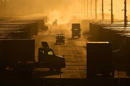 Workers drive among shipping containers and trailers at a BNSF intermodal terminal, January 3, 2024…