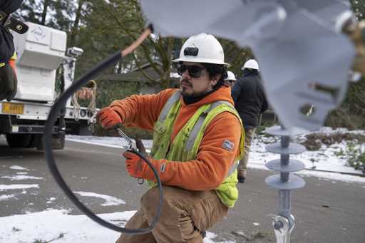 File - A worker from Portland General Electric replaces a power line as crews work to restore power…