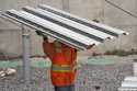 A construction worker carries steel decking at the site of a construction of a housing project, Thu…