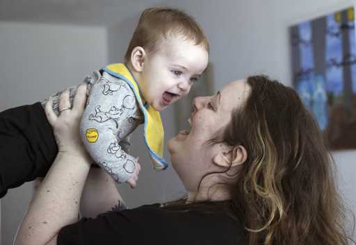 Nicole Slemp, a new mother of seven-month-old William, lifts up her son in their home, Thursday, Ma…