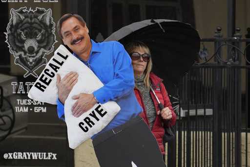 Stacy Oliver holds display of Mike Lindell, the controversial CEO of My Pillow who has advocated fa…