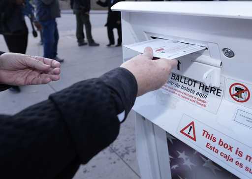 A voter places a ballot in a drop box outside the Denver Elections Division headquarters November 8…