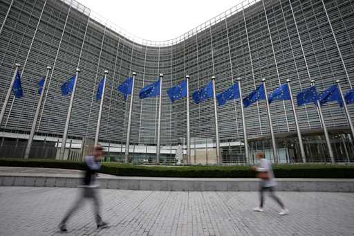 European Union flags wave in the wind as pedestrians walk by EU headquarters in Brussels, Wednesday…