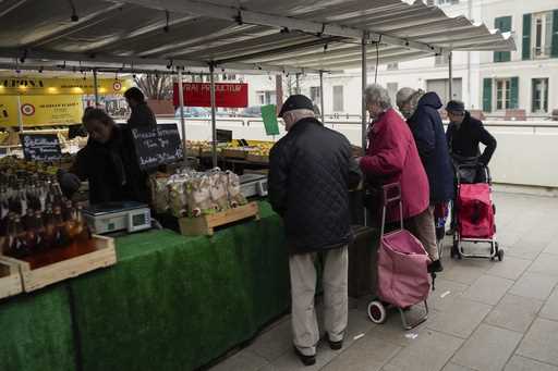 People shop at an open air market in Fontainebleau, south of Paris, France, Friday, Feb 2, 2024