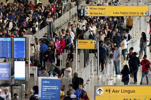 People wait in a TSA line at the John F