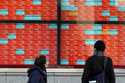 People look at an electronic stock board showing Japan's stock prices at a securities firm in Tokyo…