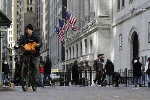 People pass the front of the New York Stock Exchange in New York, Tuesday, March 21, 2023
