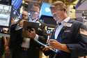 Robert Charmak, right, works on the floor at the New York Stock Exchange in New York, Wednesday, Ju…