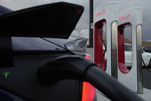 A vehicle charges at a Tesla Supercharger station in Detroit, November 16, 2022