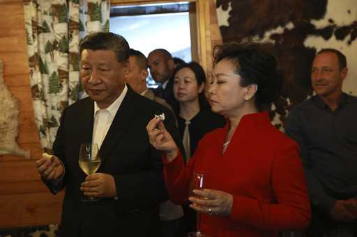 Chinese President Xi Jinping and his wife Peng Liyuan, right, enjoy a drink with French President E…