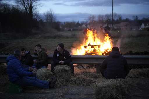 Farmers relax by a bonfire as they block a highway Tuesday, January 30, 2024 in Jossigny, east of P…