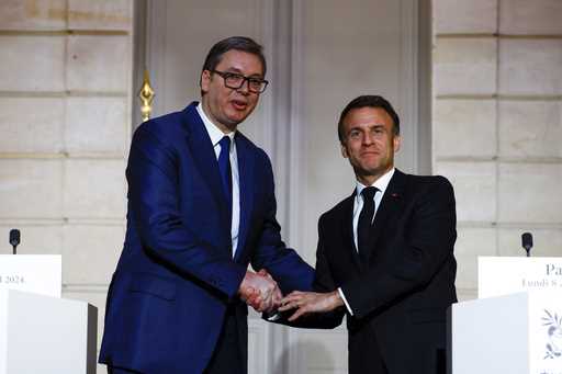 French President Emmanuel Macron, right, and Serbian President Aleksandar Vucic shake hands during …