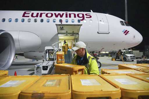 WISAG employees load a Eurowings Airbus A320-214 bound for Stuttgart with plastic boxes full of mai…
