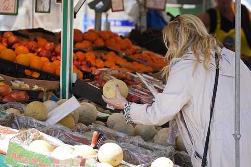 A woman checks the price of a water melon in Essen, Germany, Wednesday, May 31, 2023