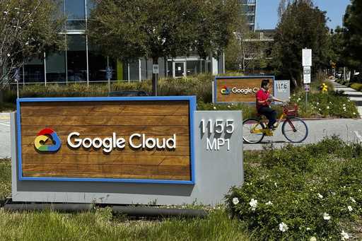 A person rides past the Google sign outside the Google offices in Sunnyvale, Calif