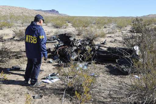 In this photo provided by the National Transportation Safety Board, an NTSB investigator surveys th…