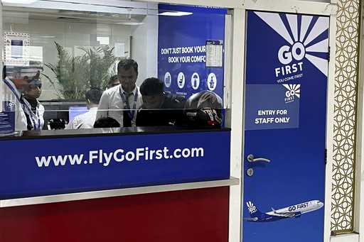Go First staff work at the airline ticket counter at Indra Gandhi International Airport in New Delh…