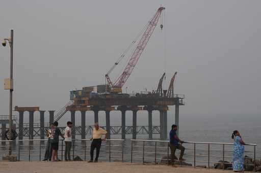 People stand near the site of the under-construction coastal road in Mumbai, India, Sunday, Februar…