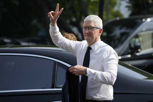 Apple CEO Tim Cook gestures upon the arrival for a meeting with Indonesian President Joko Widodo at…
