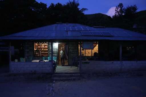 Bara Kilimandang stands at the door of his house whose electricity comes from solar energy in Walat…