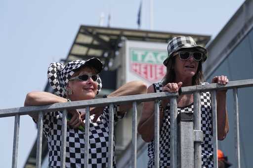 Fans watch as cars are pulled to the track during practice for the Indianapolis 500 auto race at In…