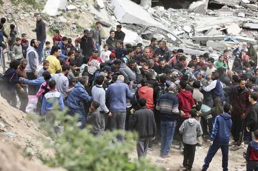 Palestinians rush to collect the humanitarian aid airdropped into Gaza City, Gaza Strip, on Sunday,…