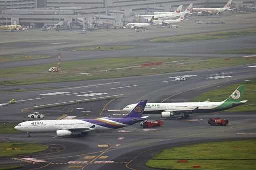 This aerial photo shows the airplanes of Thai Airways International, left, and Eva Airways, right, …