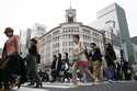 People walk across a pedestrian crossing in Ginza shopping district on March 31, 2023, in Tokyo