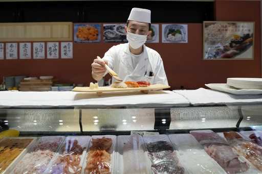 A sushi chef prepares a plate at the Toyosu Market Monday, January 29, 2024, in Tokyo