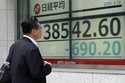 A person looks at an electronic stock board showing Japan's Nikkei 225 index at a securities firm T…