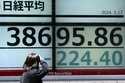 A person looks at an electronic stock board showing Japan's Nikkei 225 index at a securities firm F…