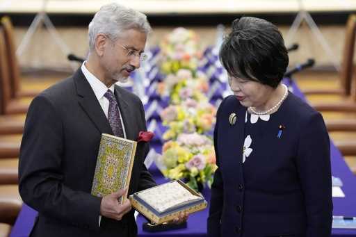 Indian Foreign Minister Subrahmanyam Jaishankar, left, gives an Indian gift to his Japanese counter…