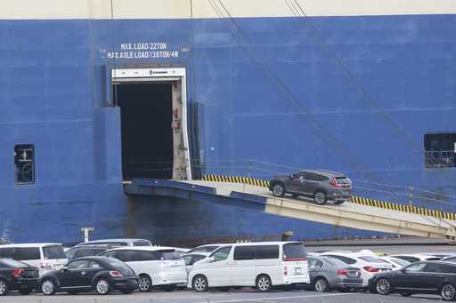Cars for export are loaded onto a cargo ship at a port in Yokohama, on November 2, 2021