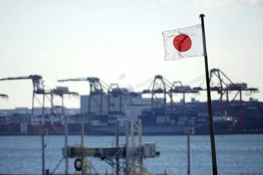 A national flag flies near a container port in Tokyo, on January 20, 2022