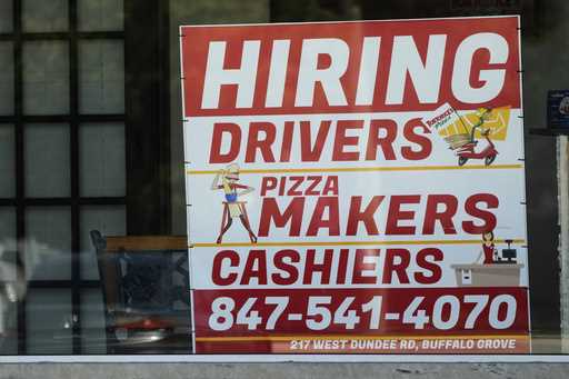 A hiring sign is displayed at a restaurant in Buffalo Grove, Ill