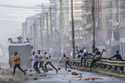 Protesters stumble as they flee from a police water cannon in the Eastleigh neighborhood of Nairobi…