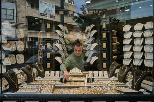 A Lebanese jeweler arranges gold ornaments at his shop's storefront in the Beirut suburb of Bourj H…