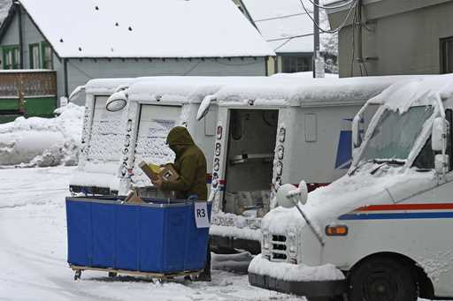 A mail carrier loads a mail truck with mail, March 1, 2024, in Lake Tahoe, Calif