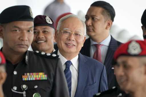 Former Malaysian Prime Minister Najib Razak arrives at the Kuala Lumpur High Court complex escorted…